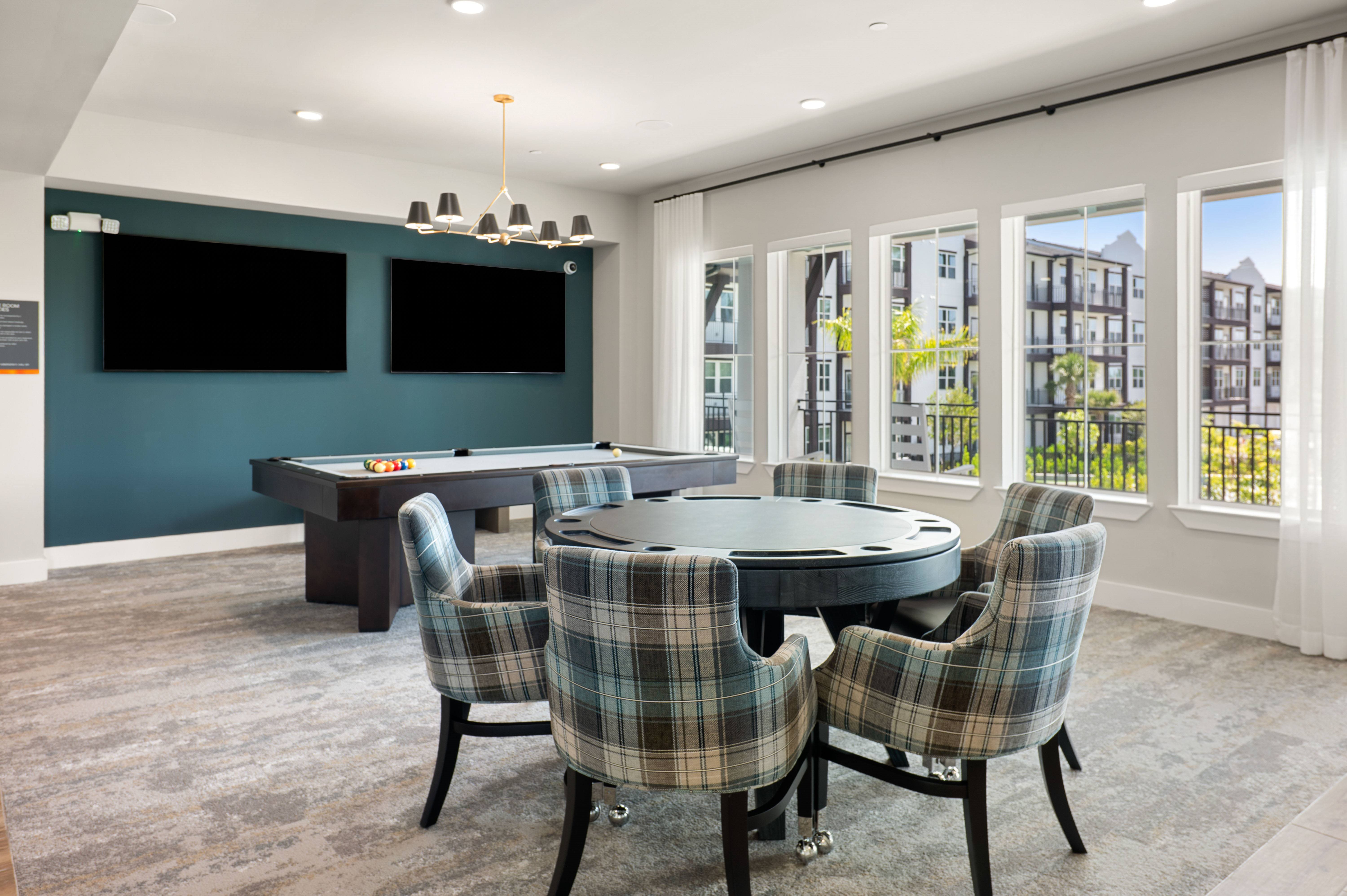 A room with a table and chairs and a television.